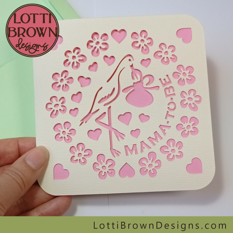 Pink and cream baby shower card with a green envelope