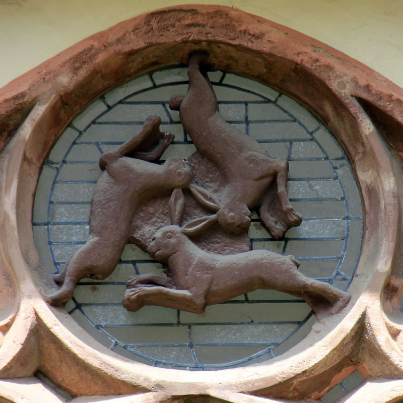 Threes hares symbol in a window at Paderburn cathedral, Germany