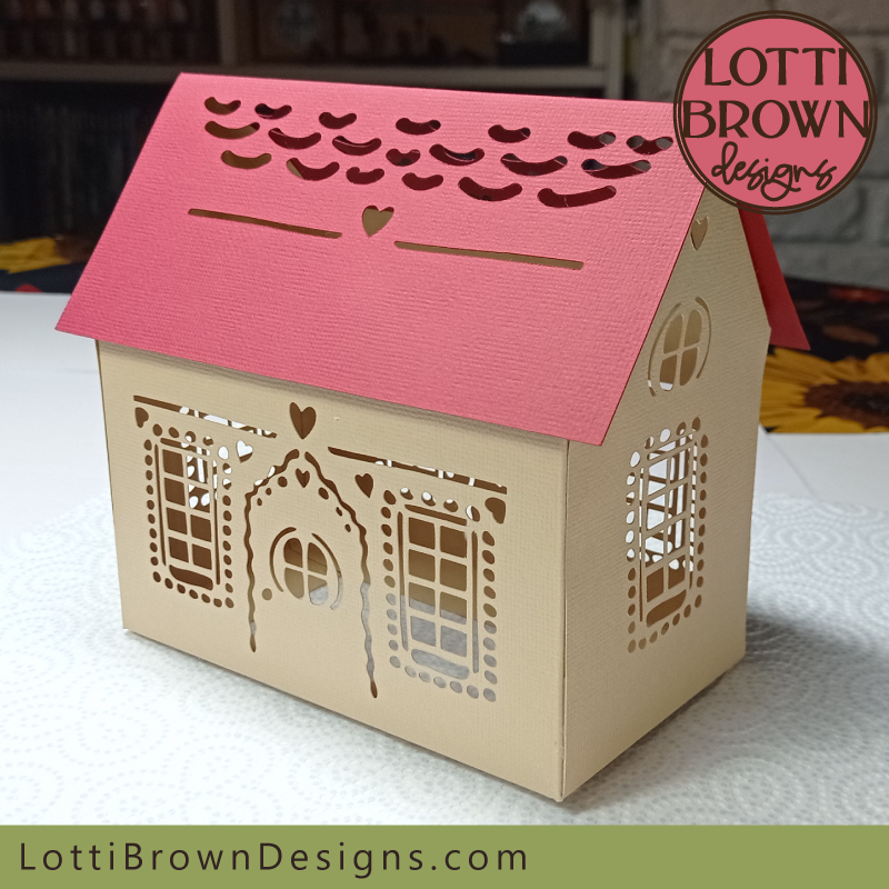 3D papercraft gingerbread house with intricate cut windows and decoration