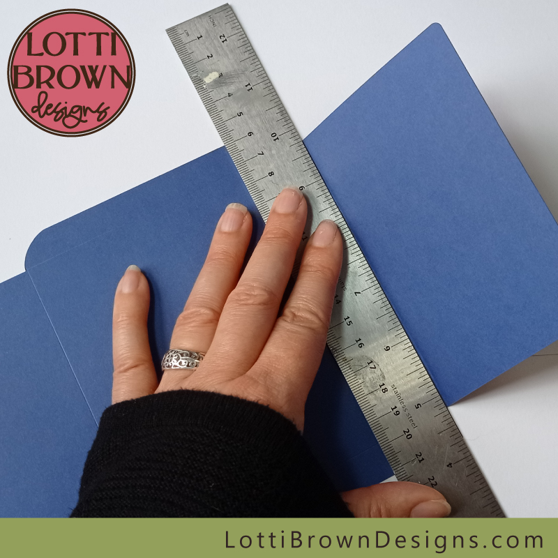 Use a metal ruler to make the folds for the envelope