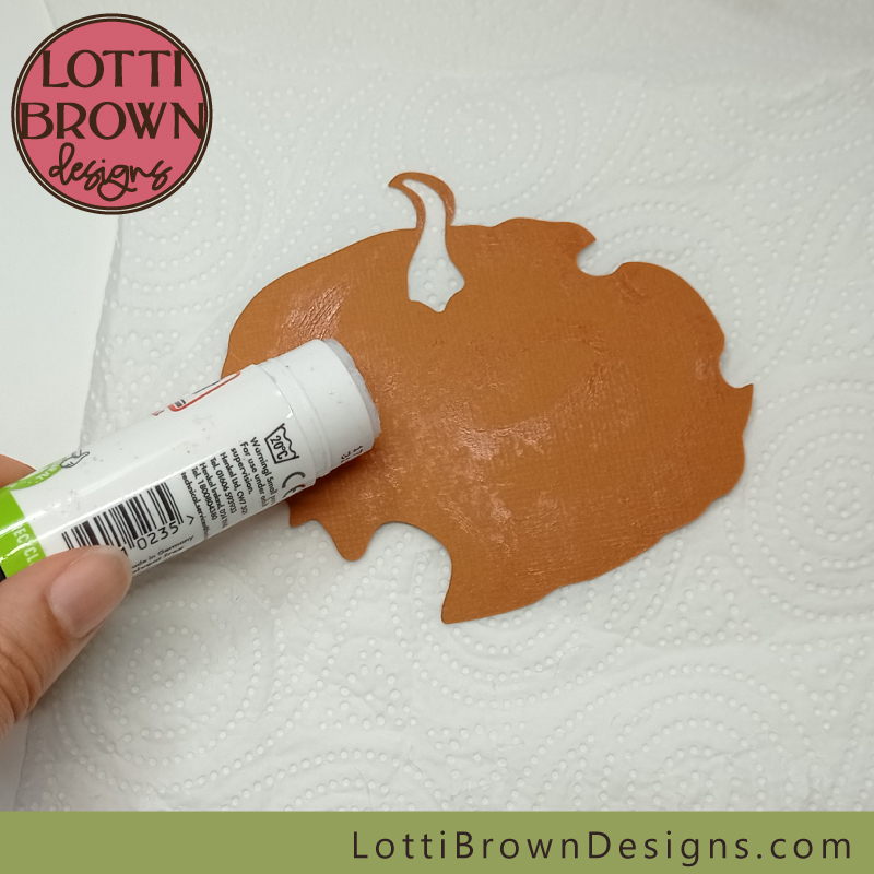 Add glue to the pumpkin shape Glue the pumpkin shape ready to add to the design